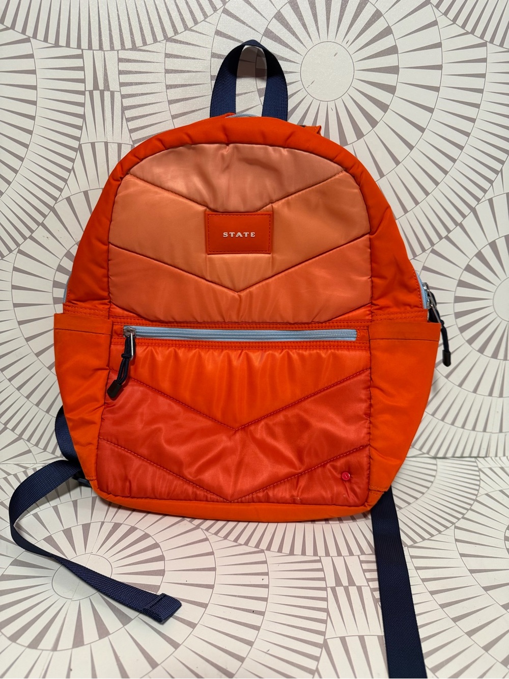 STATE Bags Kane kids backpack in an orange chevron puffer style